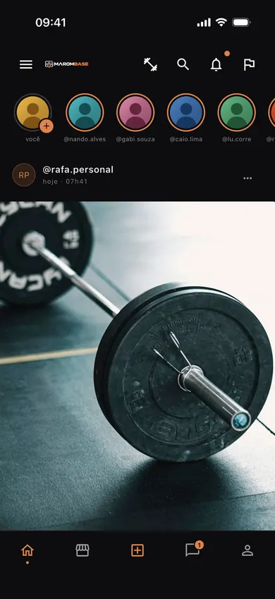 Feed do Marombase no celular: faixa de stories com amigos e, logo abaixo, a publicação de @rafa.personal com a foto de uma barra com anilhas no chão da academia.